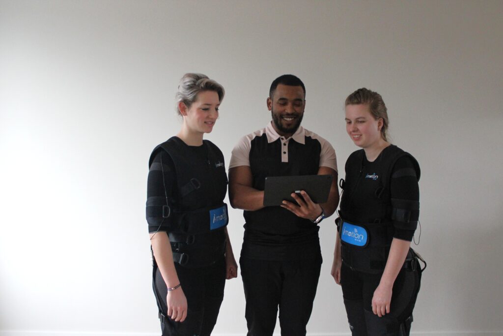 Personal trainer begeleidt klanten tijdens EMS personal training